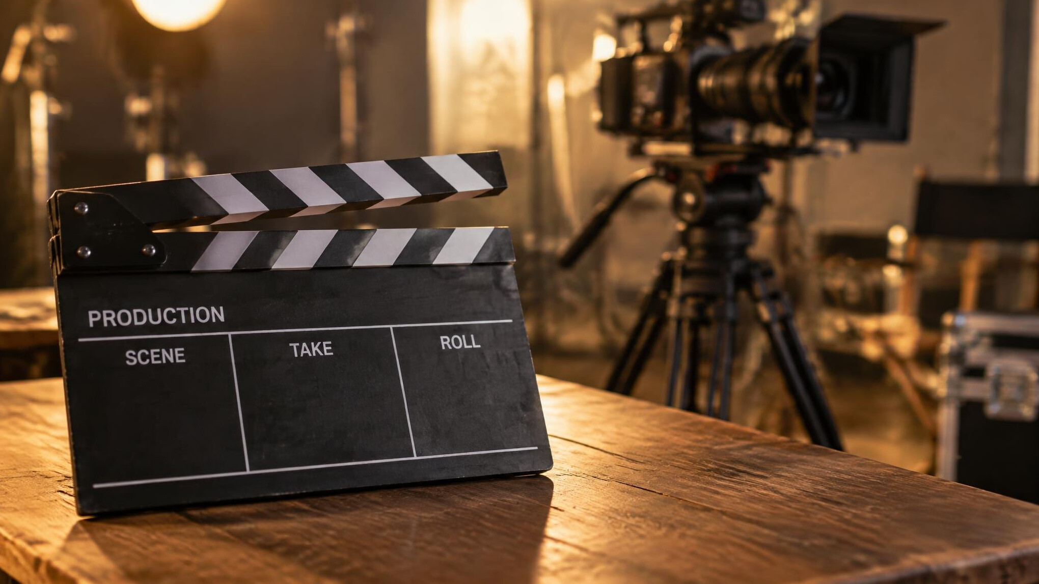 Clapperboard resting on a film set table next to a camera